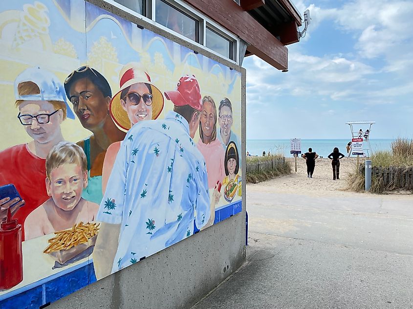 A colorful mural of a group of people marks the entrance to a popular beach.