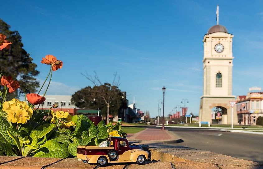 Model pickup truck with a gold pocket watch on the back of it. In the town of Feilding, New Zealand