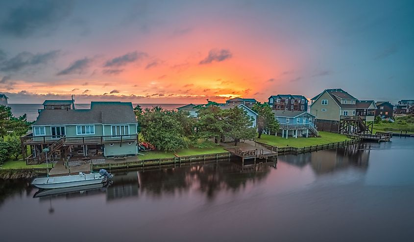 The sun sets behind a row of waterfront cottages on Hatteras Island Frisco, NC.