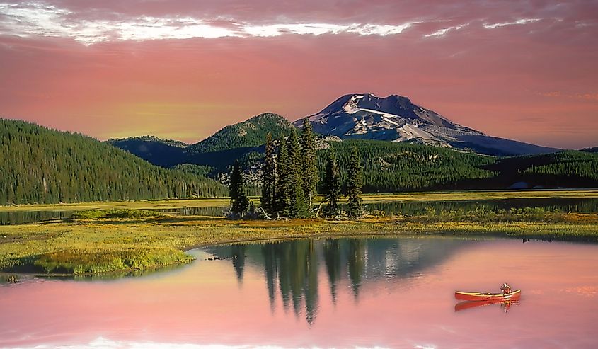  A woman in a red canoe on Sparks Lake, Oregon Cascade Mountains near Bend,