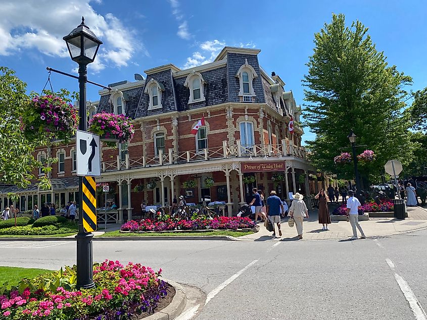 Crossing a flower-lined street toward a Victorian hotel called the Prince of Wales.