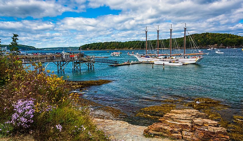 Rocky coast and view of boats in the harbor at Bar Harbor, Maine.