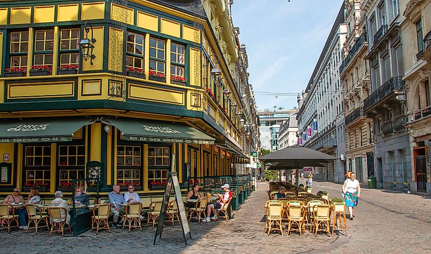 Brussels, Belgium - 6 August 2025: People enjoy their time at a charming café on a lively street in summer.