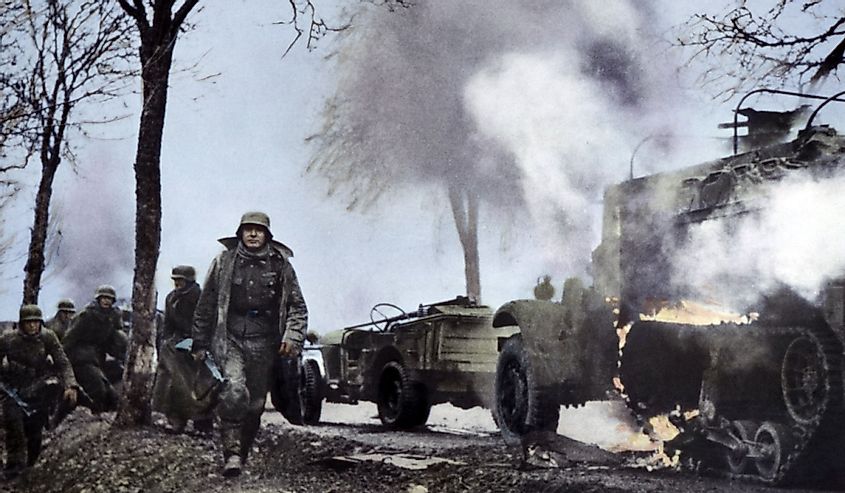 German soldiers passing burning U.S. equipment in the beginning of the Battle of the Bulge