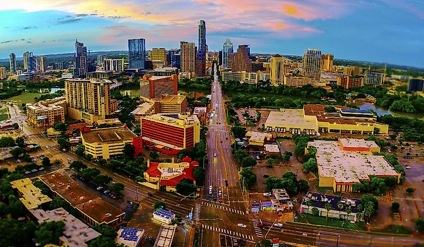 Aerial Drone Panoramic view from high above Austin Texas USA skyline cityscape over south congress or Soco downtown sunset view with pinks and colorful dramatic evening sky