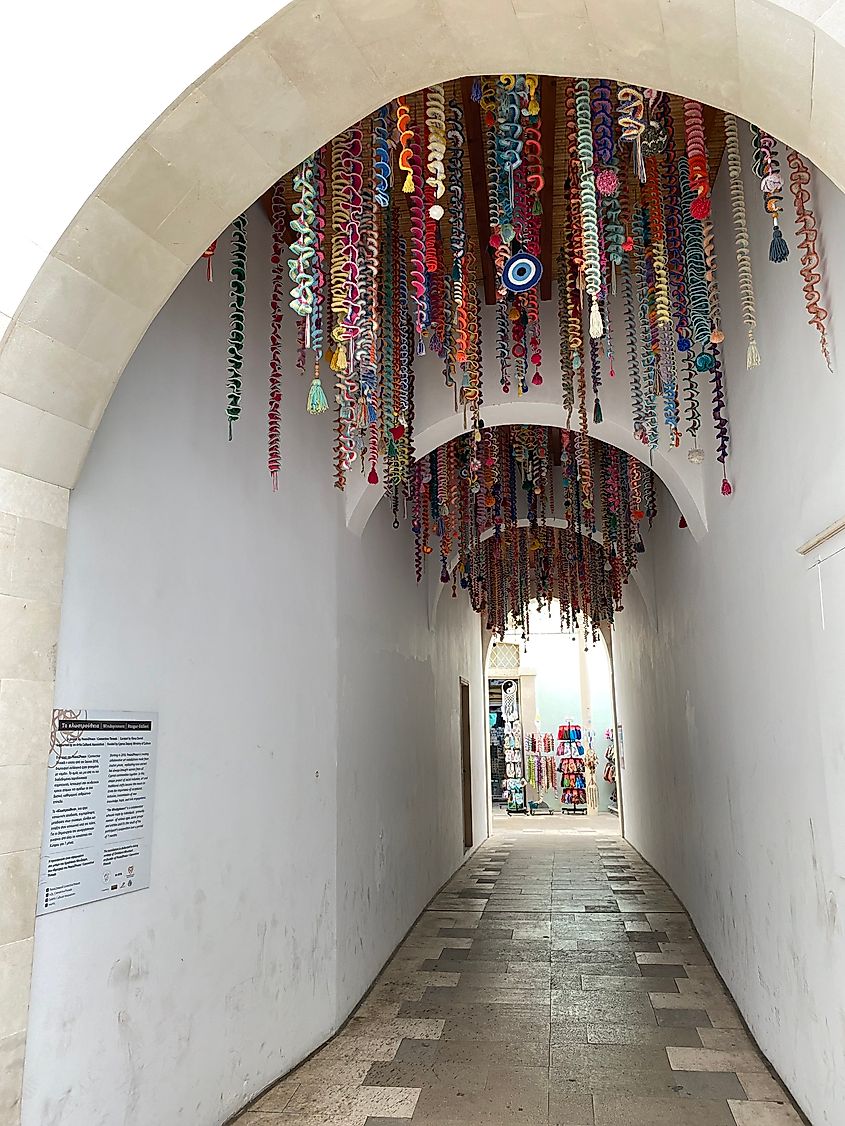 Decorative streamers hang from an alley made of white arches.