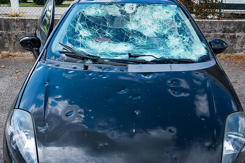 Hail damage to car, damaged hood and windshield.