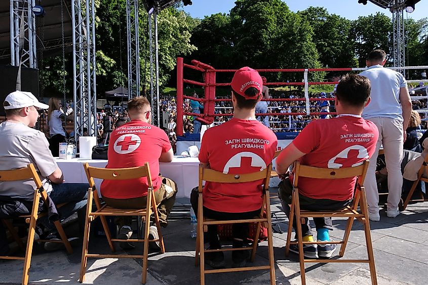 three medics sitting at a table and oversee an outdoor boxing competition. Editorial credit: Doroznik / Shutterstock.com