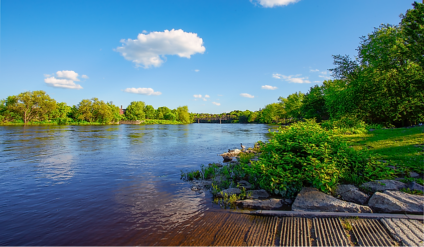 Beautiful sunny spring or summer afternoon at the Androscoggin river in Auburn Maine. Looking across the river at Auburn Maine.