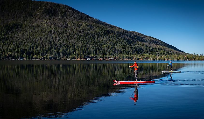 Two people paddle boarding in an empty Grand Lake due to the pandemic, during memorial weekend.