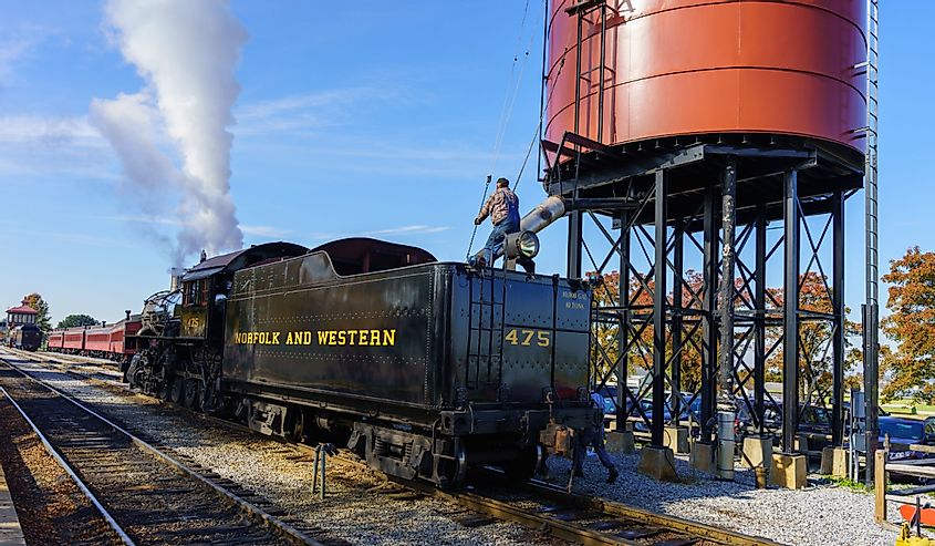 A worker on the Strasburg Rail Road, Chartered in June 1832, fills the locomotive water tank to make steam
