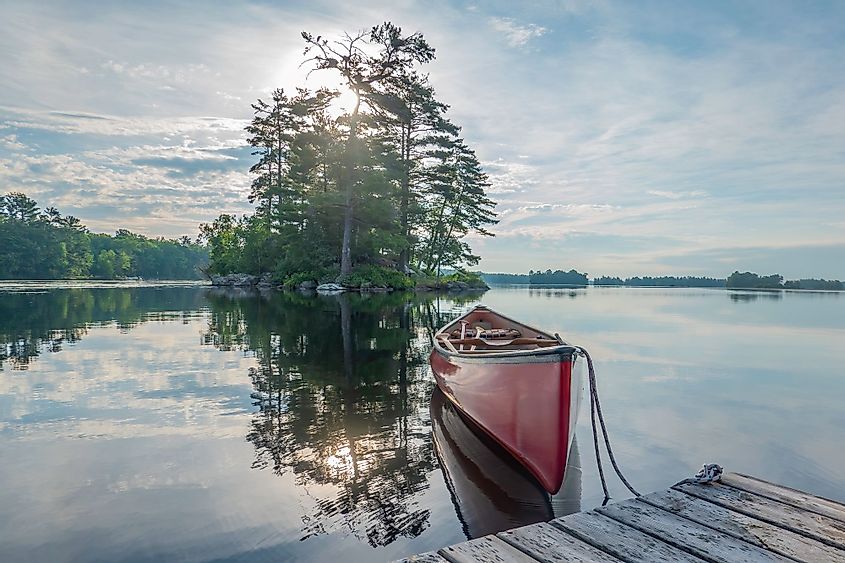 A canoe tied to a dock on the calm waters of Stony Lake in the morning.