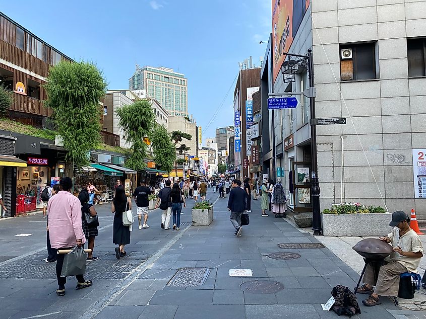 A man plays a handpan on a pedestrian street in Korea.