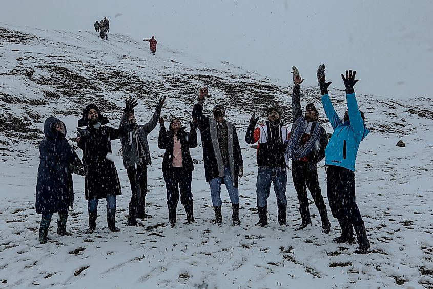 Tourists play with snow at Gulmarg, India