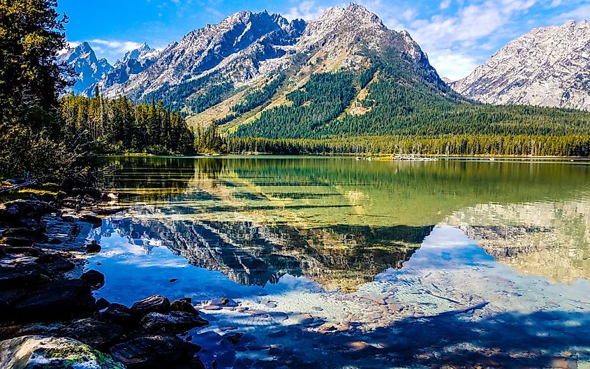 Teton mountains are in full view across Leigh Lake in Grand Teton National Park in Wyoming.