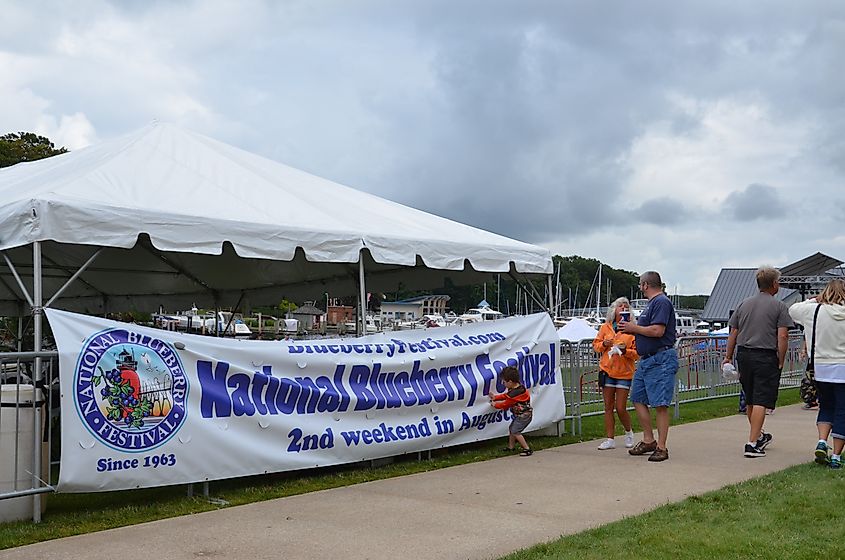Visitors stroll past a National Blueberry Festival sign at the South Haven riverfront in Michigan
