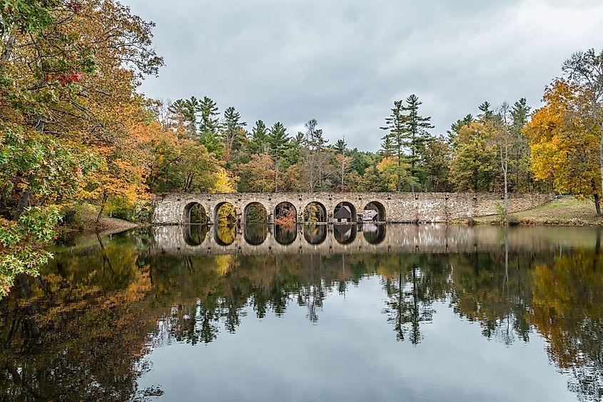 Seven Arch Bridge and colorful trees in autumn on an overcast cloudy sky a still reflection on Lake Byrd in Tennessee