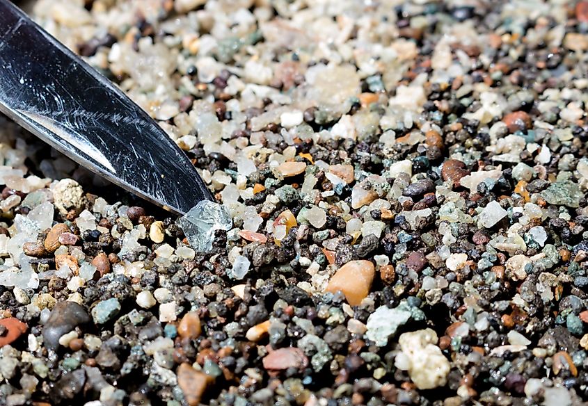 Close up of a lifting a piece of clear stone out of many tiny pebbles, Diamond hunting at Crater of Diamonds State Park.