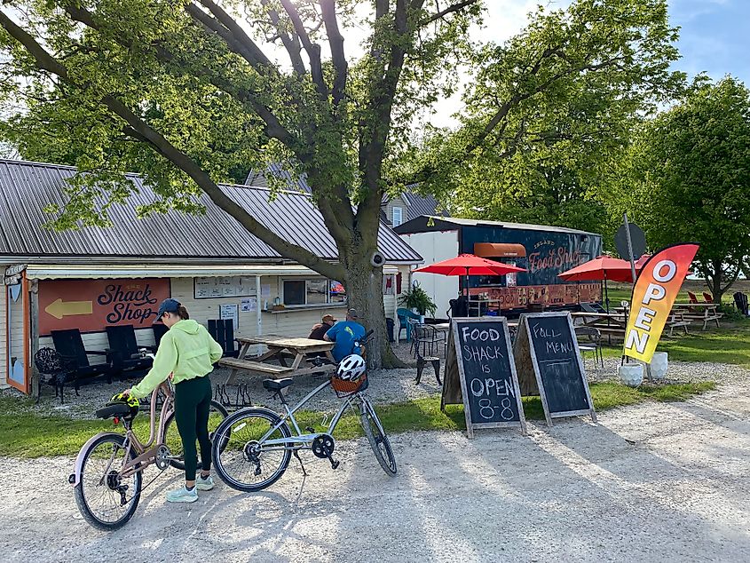 A woman parks her bike outside of a little food-truck and shop rallying point. 