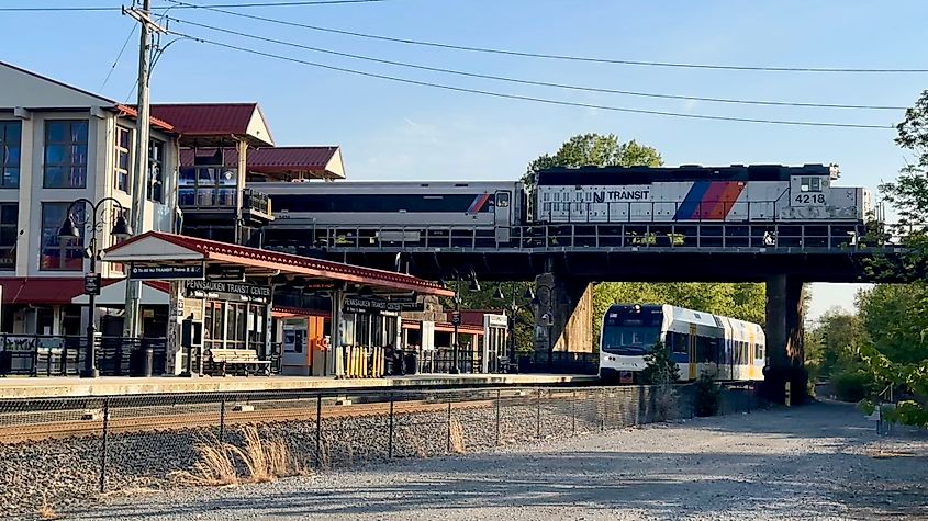 Three NJ Transit River Line trains meet at Pennsauken Junction, with tracks converging at the station platform