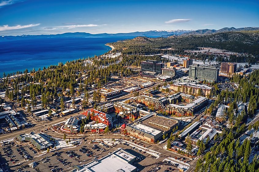 Aerial view of South Lake Tahoe, straddling the California-Nevada state line, showcasing the expansive lake and surrounding landscape.