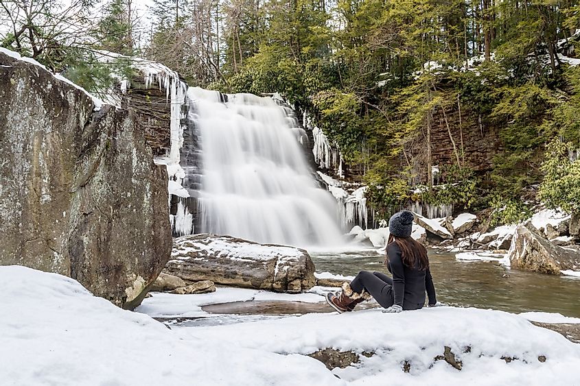 A woman admires the beauty of the Muddy Creek Falls during winter in the Shallow Falls State Park in Oakland, Maryland