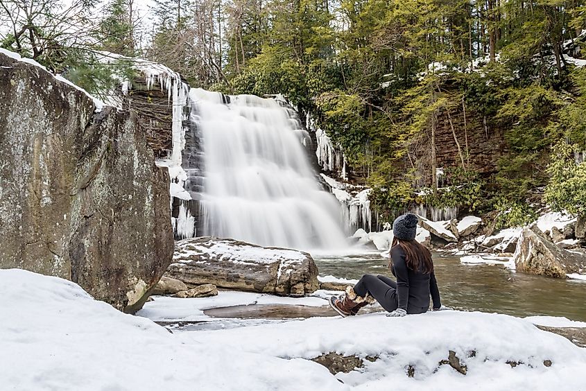 A woman admires the beauty of the Muddy Creek Falls during winter in the Shallow Falls State Park in Oakland, Maryland