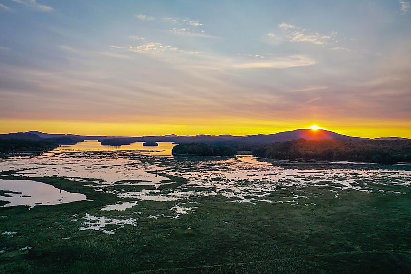 Sunset over Moody Tupper Lake NY Adirondacks in early fall aerial.