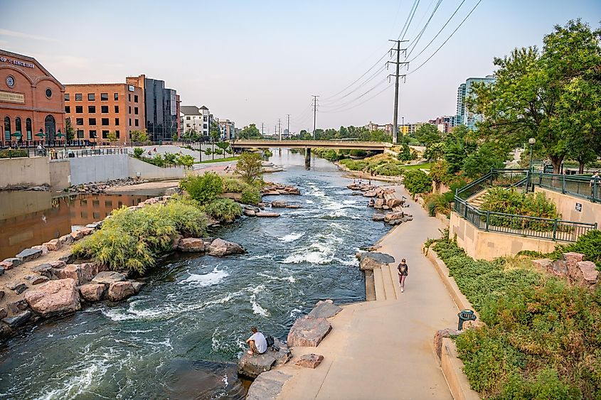 A woman goes for a walk along the creek at Confluence Park, between the Highland and River North (RiNo) neighborhoods, via Page Light Studios / Shutterstock.com