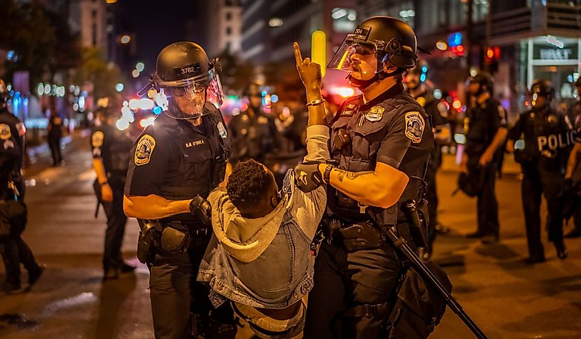 A protester is being taken by policemen