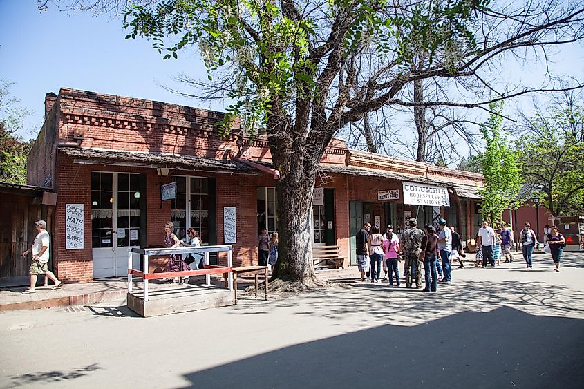 Street view of California Historical Landmark building in Columbia with people lined up near a shop.