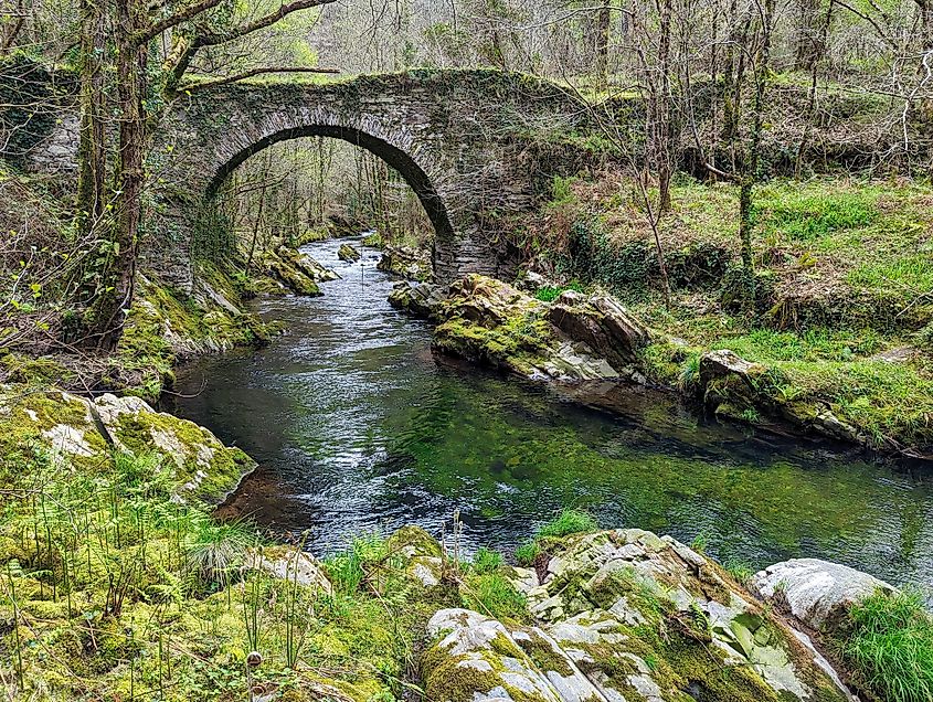 Ancient Roman bridge over the Polea river in Villayon, Asturias, Spain, Europe. Via Shutterstock / imag3s 4 u.