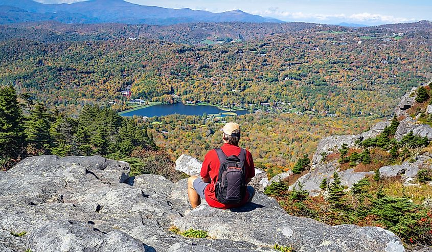 Man on hiking trip relaxing and looking at beautiful autumn mountain scenery. Grandfather Mountain State Park, Banner Elk, North Carolina.