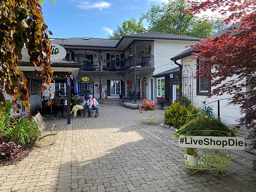 A sign reading #liveshopdie marks the entrance to a village's commercial courtyard.