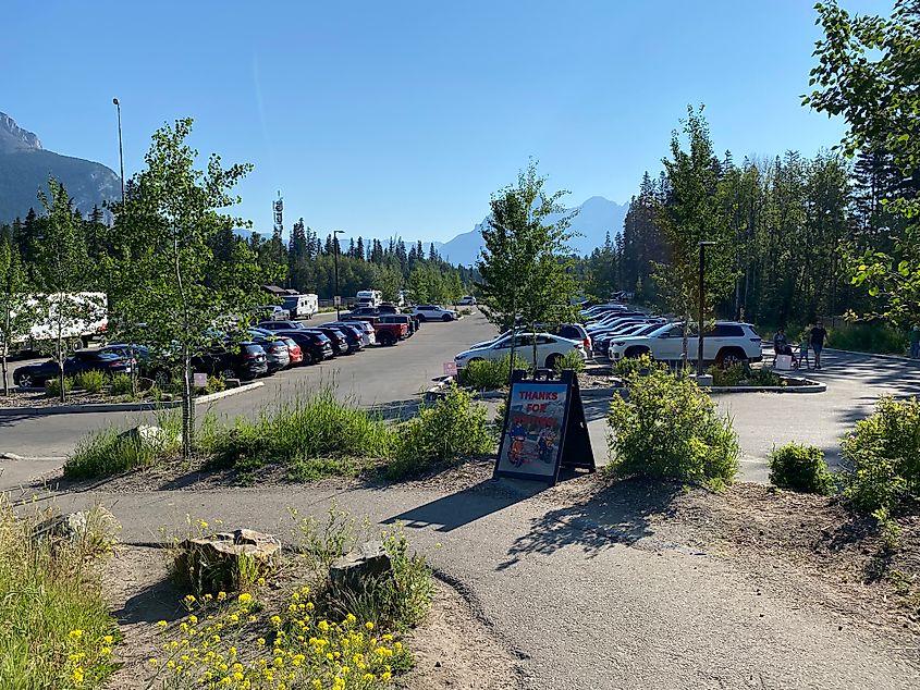 A spacious spill over parking lot amongst the trees and mountains of Banff.