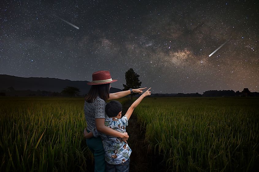 Mother and son pointing at the night sky