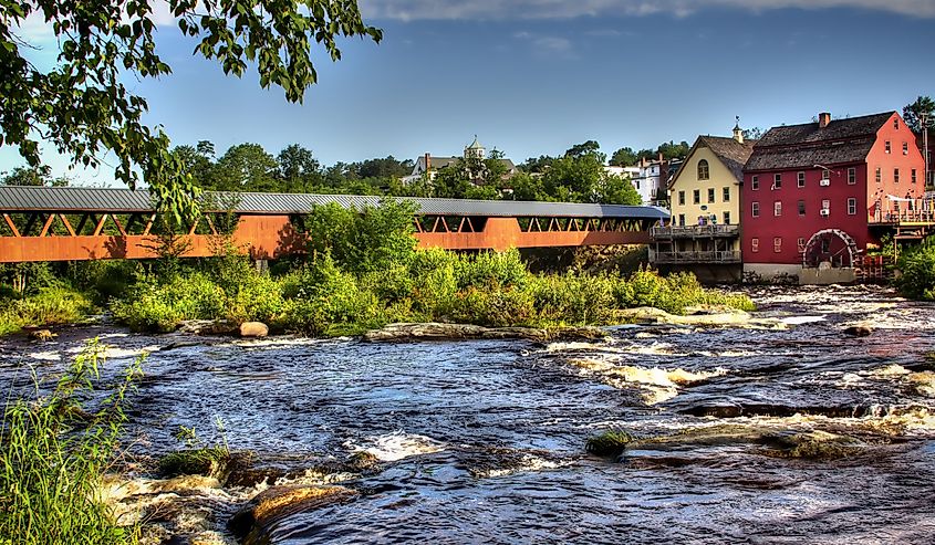 The River Walk Covered Bridge with the Grist mill on the Ammnosuoc River in Littleton New Hampshire