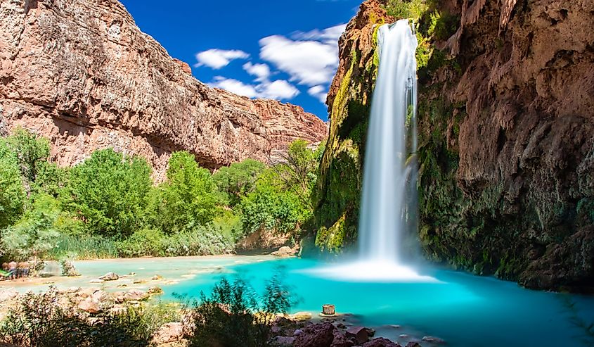 beautiful Havasu Falls with turquoise pool and green bushes surrounding