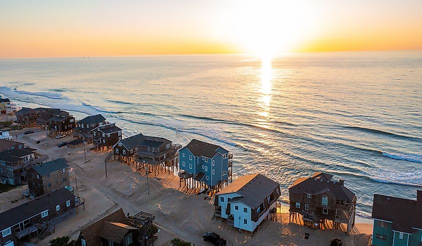 Aerial view of homes and the ocean during sunrise in Buxton, North Carolina.