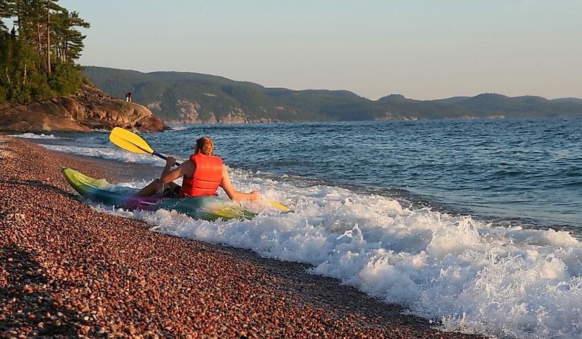 Kayaker playing in the waves at Agawa Bay. Lake Superior Provincial Park, Ontario.