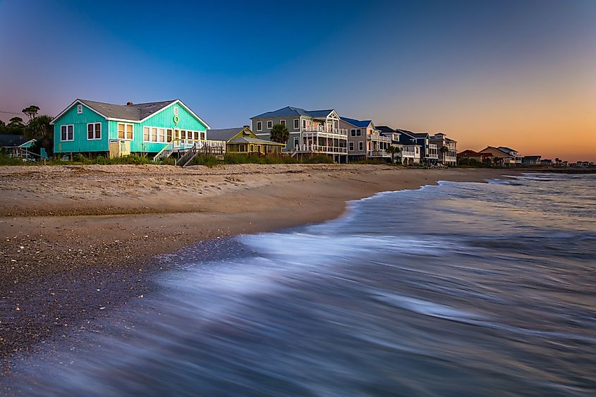 Waves in Atlantic Ocean and beachfront homes at sunrise, Edisto Beach, South Carolina.
