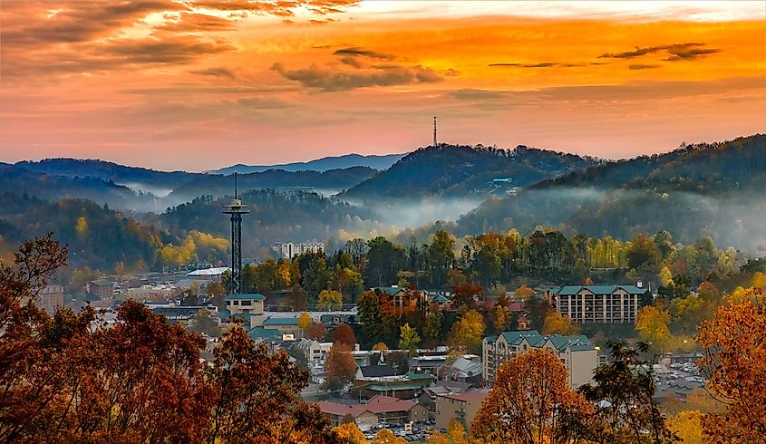  Cityscape of Gatlinburg, Tennessee, with the city enveloped in fog and surrounded by autumn-colored trees.