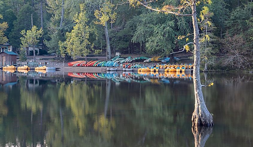 Trees line the water, and kayaks on the shore in Broken Bow, Oklahoma.