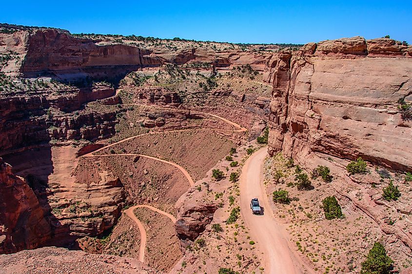 SUV on a serpentine in Canyonlands National Park Utah. Shafer Trail - winding road