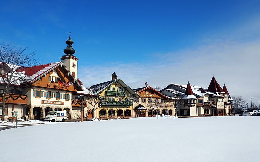 Bavarian-style houses of the Bavarian Inn center in Frankenmuth, Michigan, on a perfect winter day with a blue sky above and white snow on the ground.