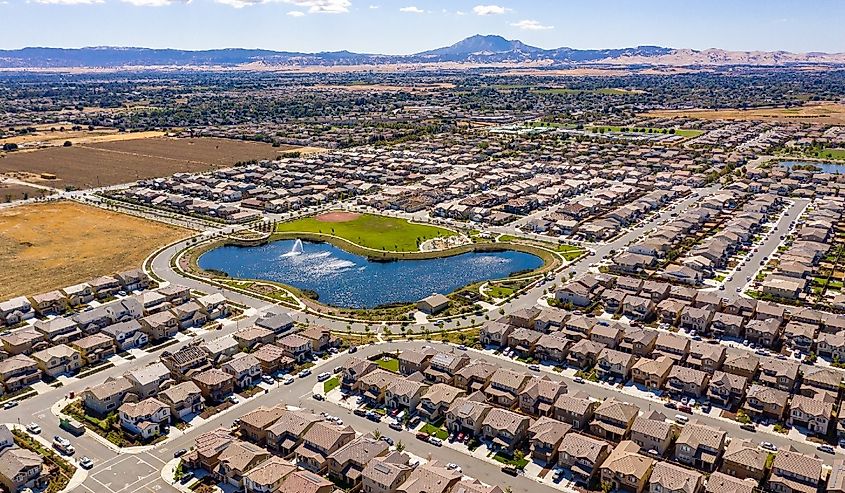 A drone photo over the Emerson Ranch community in Oakley, California with a lake and houses in the foreground