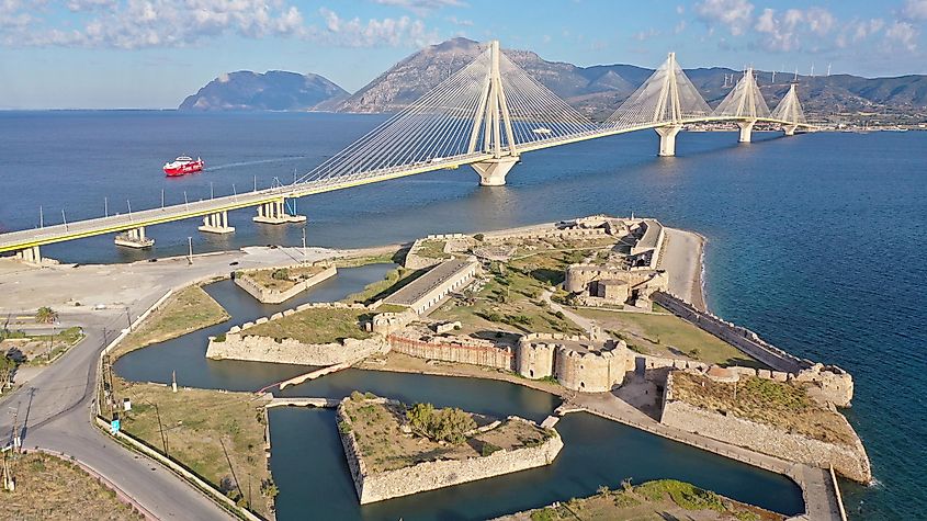 Aerial drone photo of iconic medieval ancient castle of Rio built next to modern cable strait bridge of Harilaos Trikoupis crossing corinthian Gulf, Central Greece