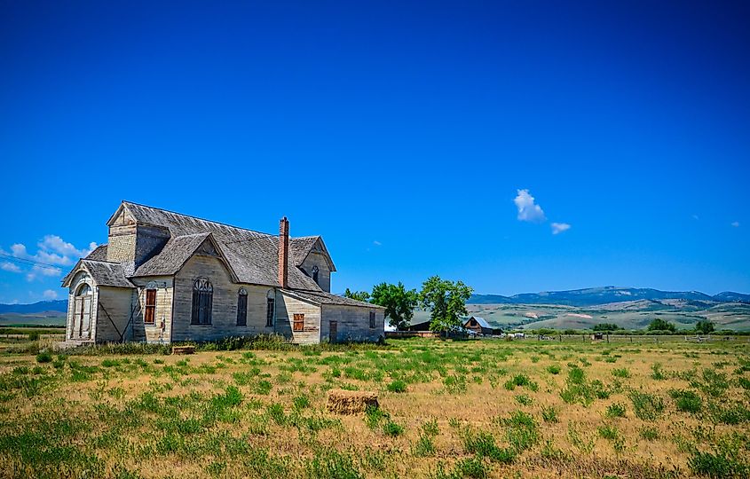 Laramie, Wyoming / USA - July 17, 2013: A deserted gray wooden house on an abandoned ranch on a lonely road in Wyoming.
