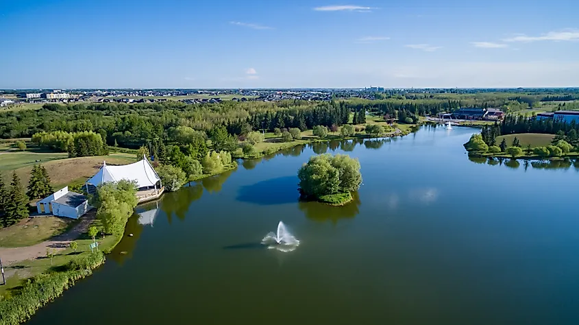 Bud Miller All Seasons Park in Lloydminster, Alberta, with walking paths, open green space, and trees surrounding a peaceful lake