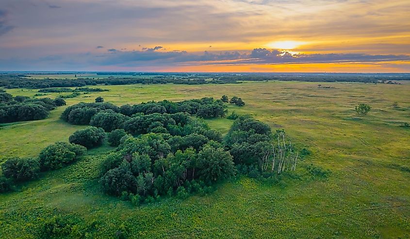 An expansive aerial view captures the Sheyenne National Grassland under a striking sunset.